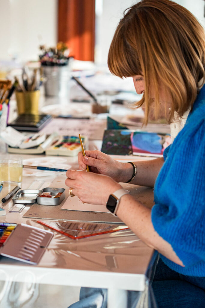 atelier en ligne femme à sa table de création qui crée