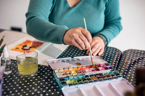 Des maisn qui prennent de la peinture dans une pallete de couleur aquarelle